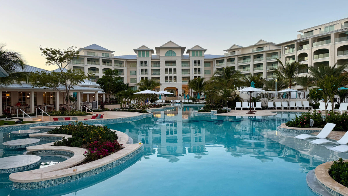 Resort buildings and palm trees surrounding a spacious pool